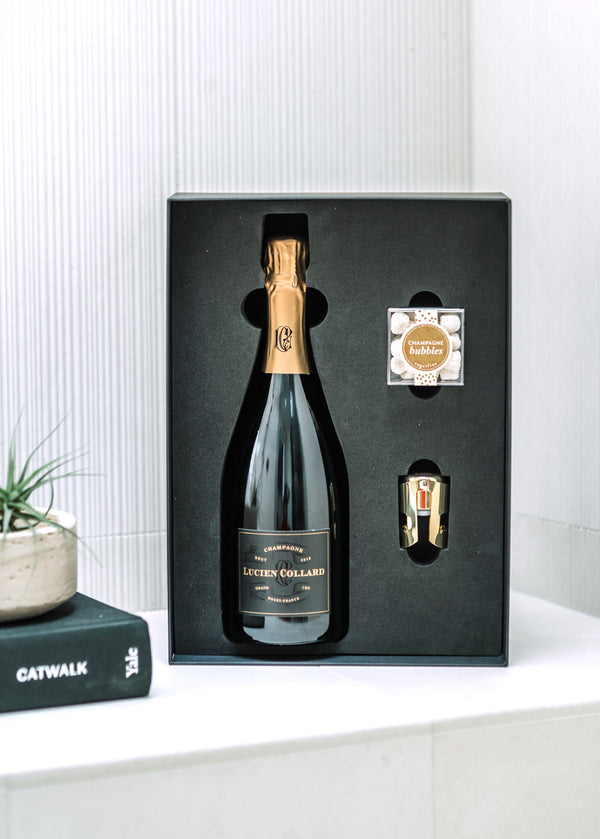 A custom branded gift box with a bottle of your choice of champagne or sparkling wine, tasting &amp; pairing notes, a SugarFina candy cube, a gold champagne stopper, and personalized gift note.